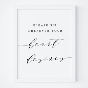 May include: White framed printable sign with black text that reads "Please sit wherever your heart desires".