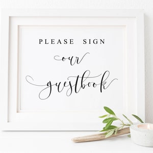May include: White framed sign with black text that reads "PLEASE SIGN our guestbook".