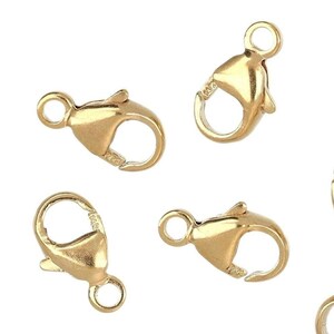 May include: Eight gold-toned lobster clasps, a type of jewelry finding used for attaching chains or cords.