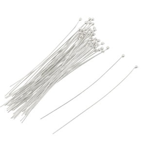 May include: A bundle of silver-toned floral wire with small round heads. The wire is straight and has a smooth finish.