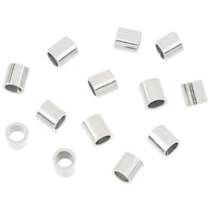 May include: A group of 12 silver-toned metal crimp beads, scattered on a white background.