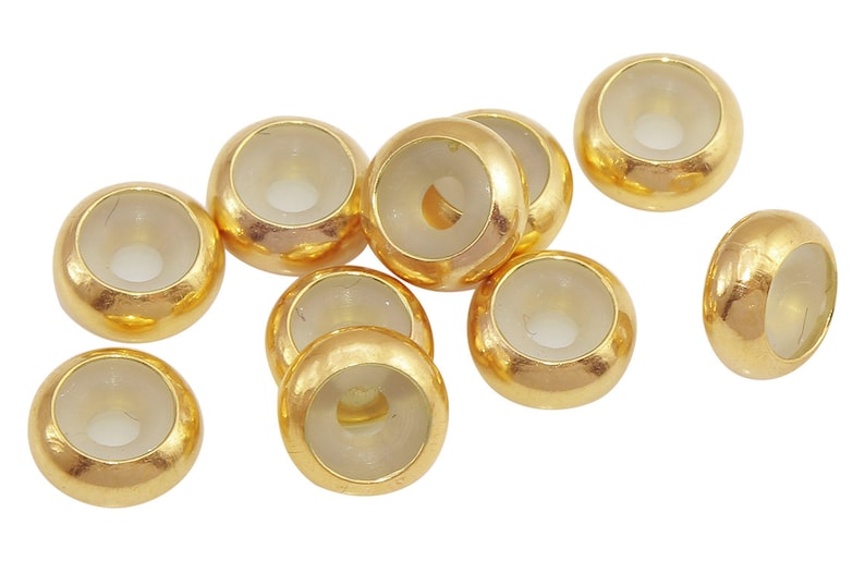 May include: Ten gold-colored beads with clear glass centers. The beads are round and have a hole in the center.