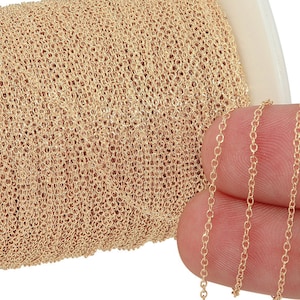 Puede incluir: Un carrete de cadena de color dorado, con una longitud de la cadena mostrada en un dedo.