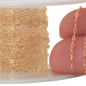 Könnte beinhalten: Eine Spule mit goldfarbener Kette, mit einer Nahaufnahme der Kettenglieder. Die Kette besteht aus kleinen, ovalen Gliedern.