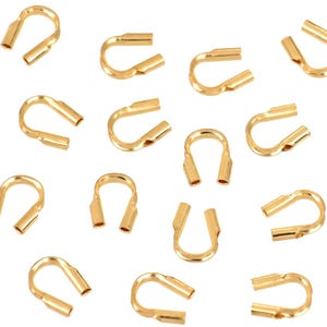 Op de afbeelding: Een verzameling gouden metalen krimpparels, ook wel krimpbuizen genoemd, die worden gebruikt voor het maken van sieraden. Deze kralen zijn ontworpen om sieraden te beveiligen en te versterken.