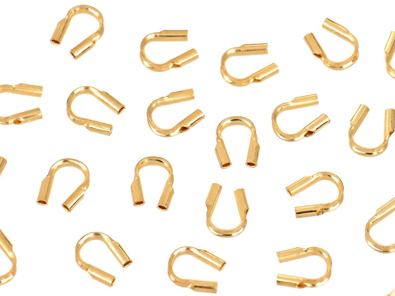 Op de afbeelding: Een verzameling gouden metalen krimpparels, ook wel krimpbuizen genoemd, die worden gebruikt voor het maken van sieraden. Deze kralen zijn ontworpen om sieraden te beveiligen en te versterken.