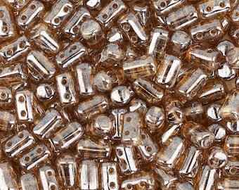 May include: A close-up of a pile of small, translucent, brown glass beads with a metallic sheen. The beads are rectangular in shape with two holes on each side.