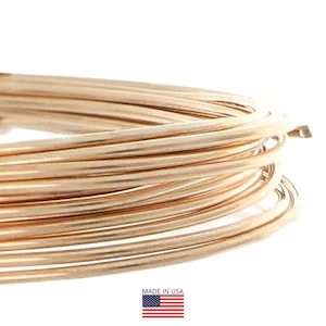 May include: Close-up of a coil of gold-colored wire. The wire is tightly wound, with a smooth, metallic finish. The image includes a small American flag with the text "MADE IN USA".