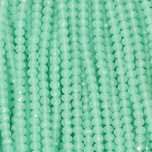 May include: Close-up of strands of light green faceted beads. The beads are strung together in vertical lines, creating a textured surface. The beads have a sparkling, translucent appearance, and are evenly spaced.