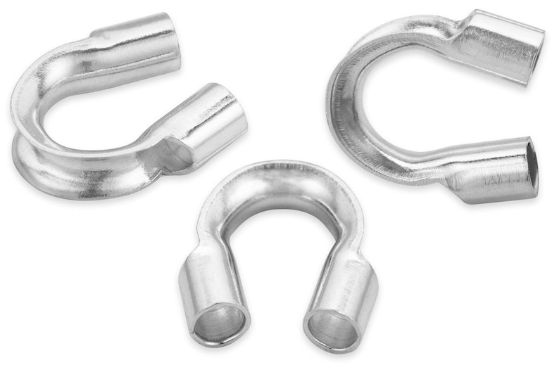 Op de afbeelding: Drie zilverkleurige U-vormige metalen componenten. Elk stuk heeft een gebogen lichaam met cilindrische uiteinden. De objecten zijn geplaatst tegen een witte achtergrond, wat hun vorm en metalen glans benadrukt.