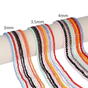 May include: Strands of colorful faceted beads in various sizes: 3mm, 3.5mm, and 4mm. The beads are displayed in a variety of colors, including red, blue, black, orange, and pink. The beads are strung together, ready for jewelry making.