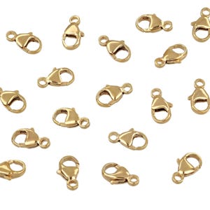 May include: Twenty gold-tone lobster clasps, a type of jewelry finding used for attaching chains or cords to jewelry pieces.