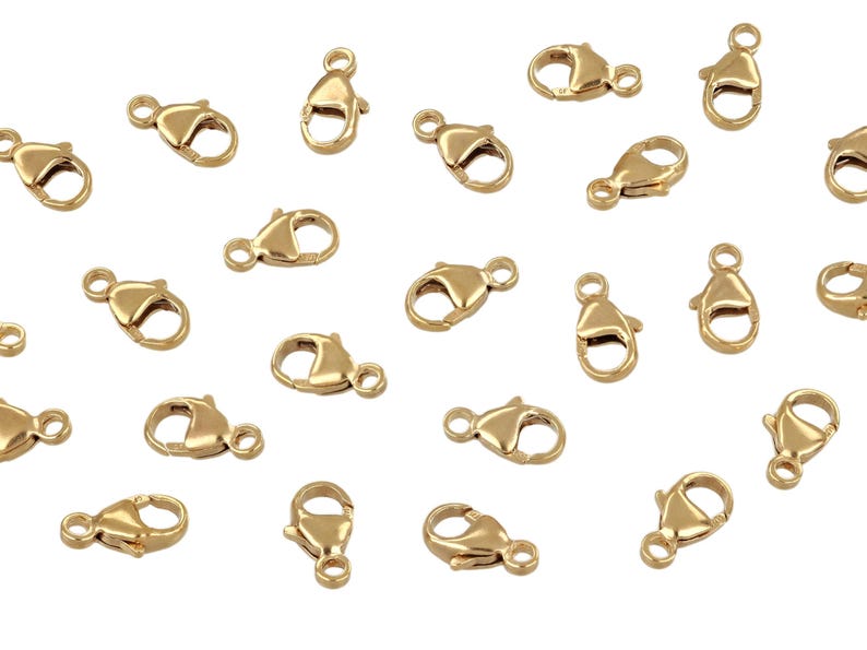 May include: Twenty gold-tone lobster clasps, a type of jewelry finding used for attaching chains or cords to jewelry pieces.