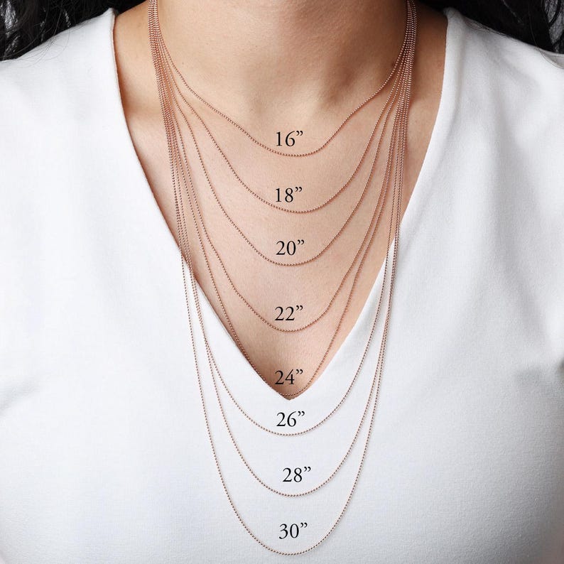 May include: A selection of delicate rose gold ball chain necklaces, displayed at various lengths. The lengths are labeled: 16", 18", 20", 22", 24", 26", 28", and 30". The necklaces are shown against a white background.