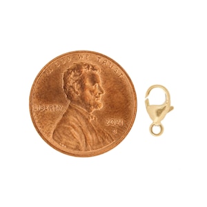 May include: Gold-toned lobster clasp closure for jewelry making. The clasp is shown next to a US penny for size comparison.