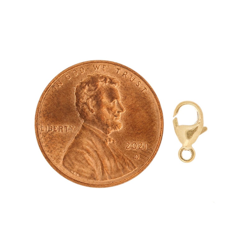 May include: Gold-toned lobster clasp closure for jewelry making. The clasp is shown next to a US penny for size comparison.