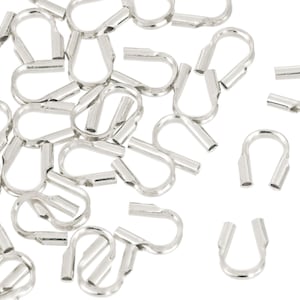 Op de afbeelding: Een verzameling zilverkleurige, metalen S-vormige krimpaansluitingen, gebruikt voor het maken van sieraden en ambachten. De connectoren hebben een lus aan &eacute;&eacute;n uiteinde en een krimpkoker aan het andere.