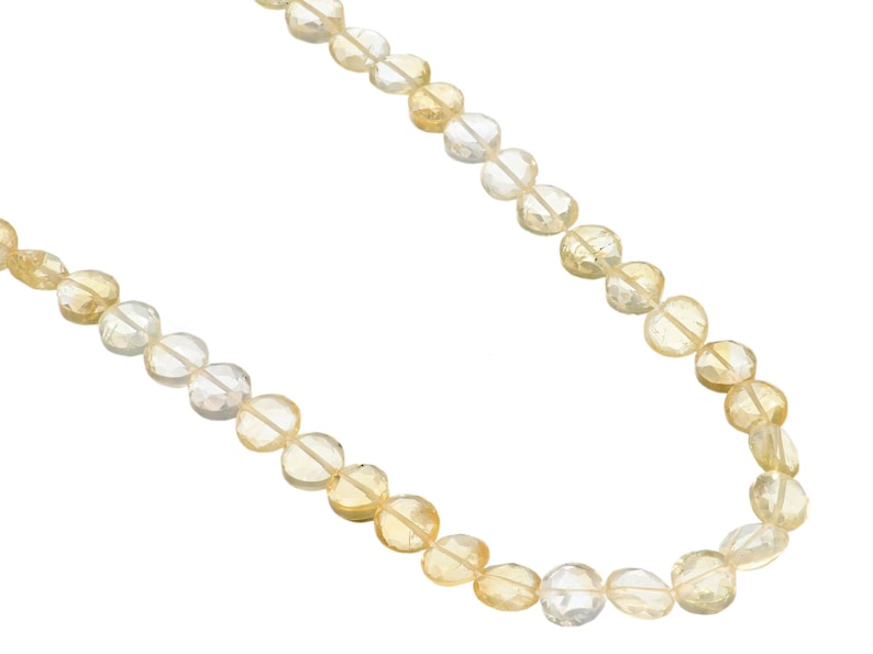 May include: A necklace composed of faceted, round citrine gemstones. The beads transition in color from pale yellow to a deeper golden hue. The necklace is displayed against a white background, highlighting the gemstones' clarity and color.