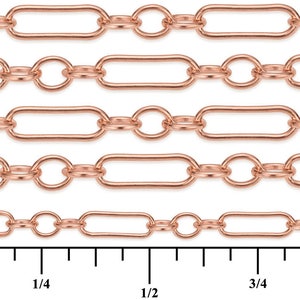 May include: Close-up of a rose gold chain with oval and round links. The chain is shown against a white background with a ruler for scale. The ruler shows measurements in inches.