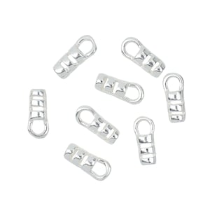 May include: Silver-toned metal clasps with a rectangular shape and a small loop at the top. The clasps have a textured design with multiple ridges.