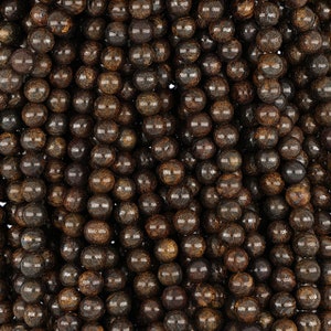 May include: A close-up of a strand of brown and gold gemstone beads. The beads are round and have a smooth, polished finish.