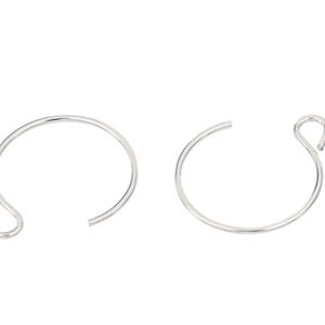 Pode incluir: Dois brincos de argola abertos prateados. Cada brinco é uma fina faixa de metal curvada com um pequeno laço numa extremidade. Os brincos são exibidos sobre um fundo branco.
