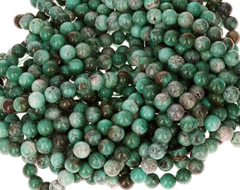 Peut inclure: Un brin de perles de turquoise vertes. Les perles sont rondes et ont un aspect marbré et moucheté.