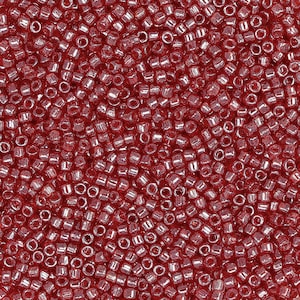 May include: A close-up image of a large quantity of small, red, round seed beads. The beads have a shiny, iridescent finish.