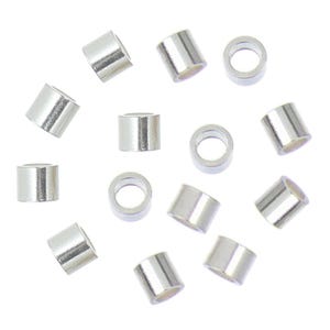 May include: A group of silver jump rings, scattered on a white background. The rings are small and round, with a smooth, shiny finish.