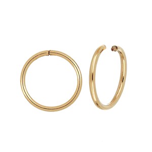 May include: Two gold-colored hoop earrings. One earring is closed, while the other is open at the top. The earrings are round and have a smooth, polished surface. The background is white.