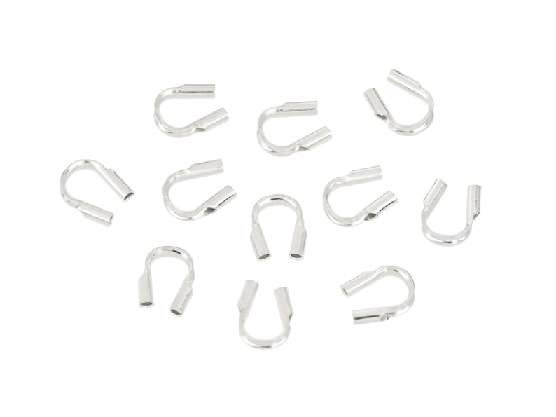 Op de afbeelding: Een verzameling zilverkleurige, U-vormige krimpeindstukken, ontworpen voor het maken van sieraden. Elk eindstuk heeft aan elk uiteinde een platte, rechthoekige opening en een gebogen, afgerond middengedeelte. De eindstukken zijn verspreid op een witte achtergrond.