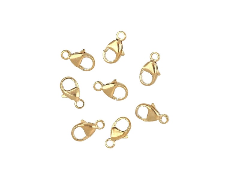 May include: Eight gold-toned lobster clasps, a type of jewelry finding used for attaching chains or cords.