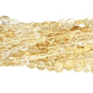 May include: Strands of polished, oval-shaped citrine gemstone beads. The beads are a translucent yellow-orange color, with a faceted surface. The beads are strung together, creating a flowing, textured appearance. Ideal for jewelry making.