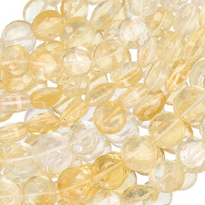 May include: A collection of faceted citrine gemstone beads in various shapes and sizes. The beads range in color from pale yellow to a deeper golden hue, with a translucent quality.