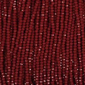 Peut inclure: Gros plan sur une collection de perles rondes et facettées de couleur bordeaux foncé. Les perles sont enfilées, créant une surface texturée et à motifs. Idéal pour la fabrication de bijoux ou les projets d'artisanat.