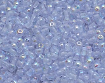 May include: A large quantity of small, light blue glass beads with an iridescent finish. The beads are round and have a hole in the center.
