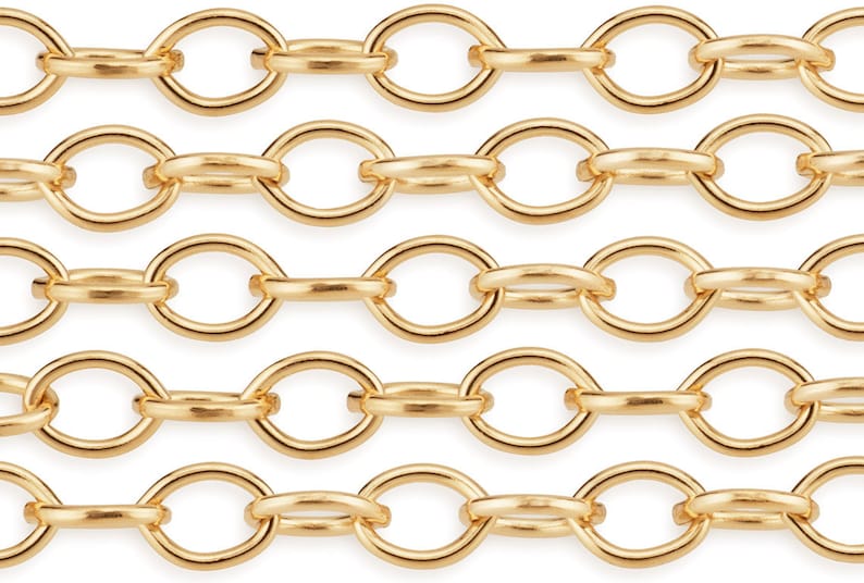 Puede incluir: Primer plano de una cadena de oro con eslabones ovalados. La cadena est&aacute; hecha de metal y tiene un acabado brillante.