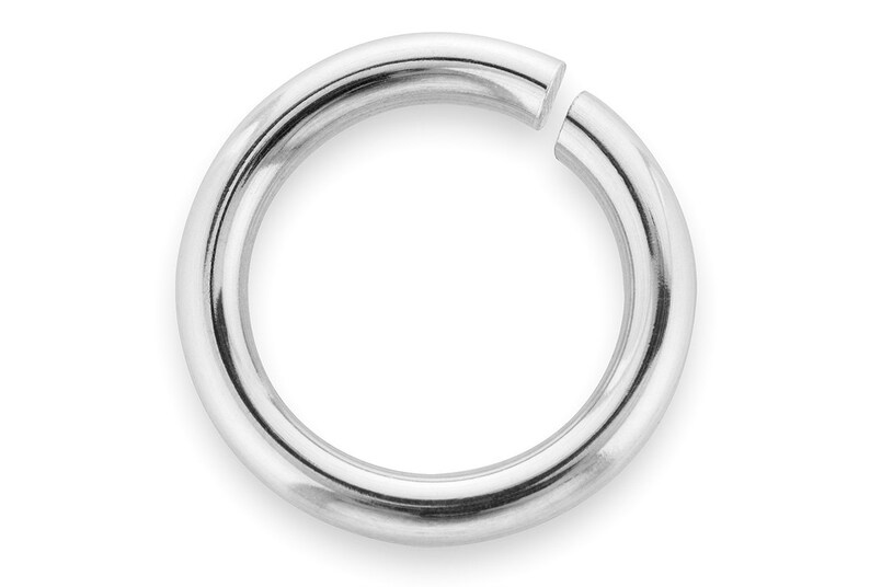 May include: A silver jump ring, a metal ring with a gap, used for jewelry making.