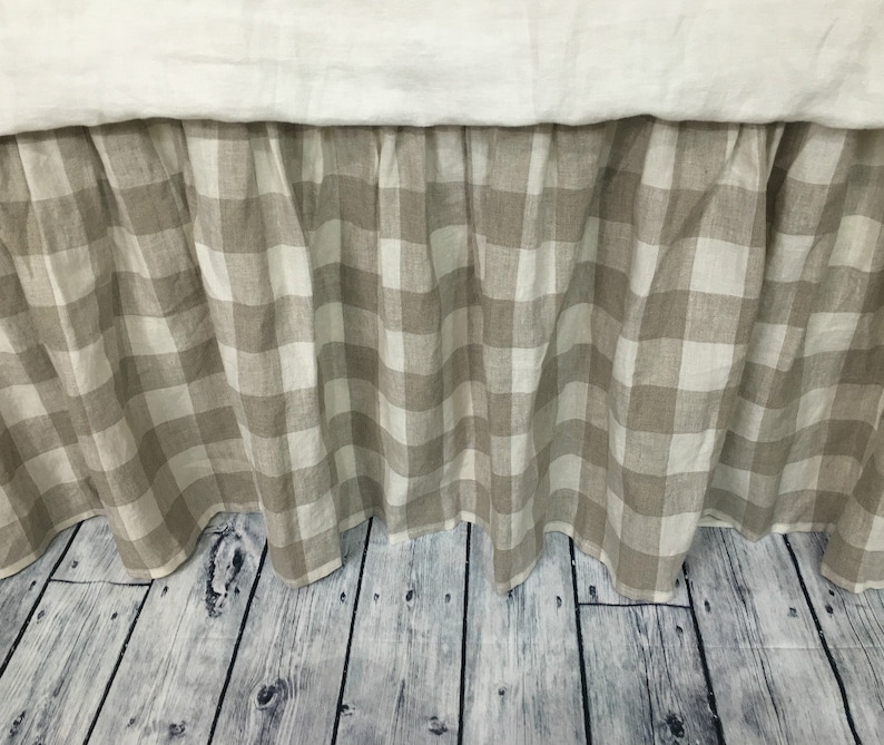 Pu&ograve; includere: Una gonna da letto beige e bianca a quadri con un bordo arricciato. La gonna &egrave; realizzata in lino e ha uno stile rustico informale.