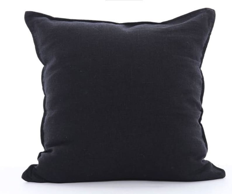 K&ouml;nnte beinhalten: Ein schwarzes quadratisches Kissen mit weichem, strukturiertem Stoff. Das Kissen ist aus einer Leinenmischung gefertigt und hat ein schlichtes, elegantes Design.