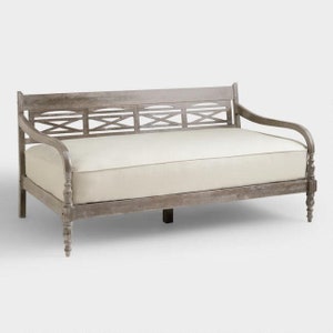 May include: A weathered gray wooden daybed with a white linen mattress and a slatted back.