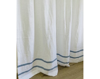 Puede incluir: Cortinas de lino blanco con dos rayas azules a lo largo del borde inferior.