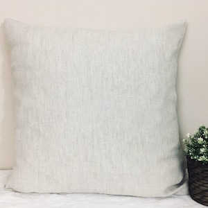 May include: A white linen pillow cover with a subtle textured pattern. The pillow cover is square and has a simple, minimalist design.