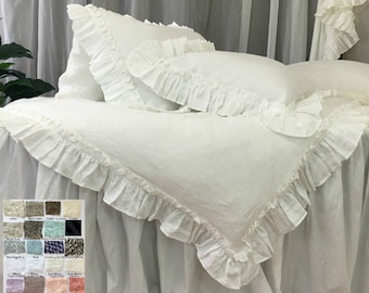 May include: White linen bedding set with ruffled edges. The set includes a duvet cover and two pillowcases. The bedding is made of 100% linen and is soft and comfortable.