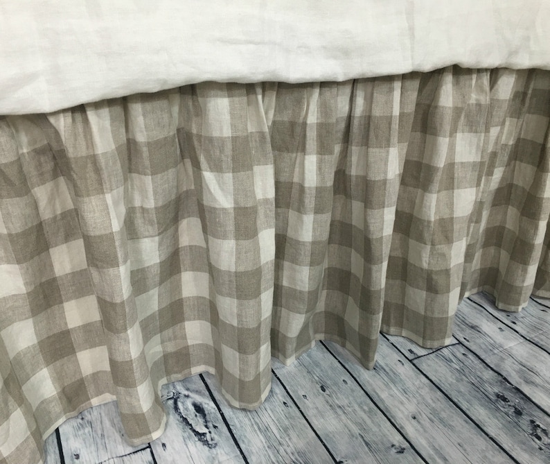 Pu&ograve; includere: Una gonna da letto in gingham beige e bianco con un bordo arricciato. La gonna &egrave; realizzata in lino e ha uno stile rustico informale.