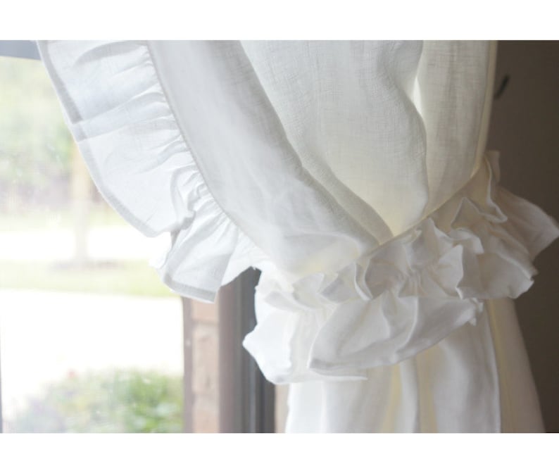 Puede incluir: Cortinas blancas de lino transparente con un ribete de volantes. Las cortinas est&aacute;n reunidas en la parte superior y atadas con una cinta.