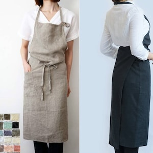 May include: Two linen aprons, one in a light beige color and the other in a dark charcoal gray. Both aprons have a simple design with a single pocket and adjustable ties.