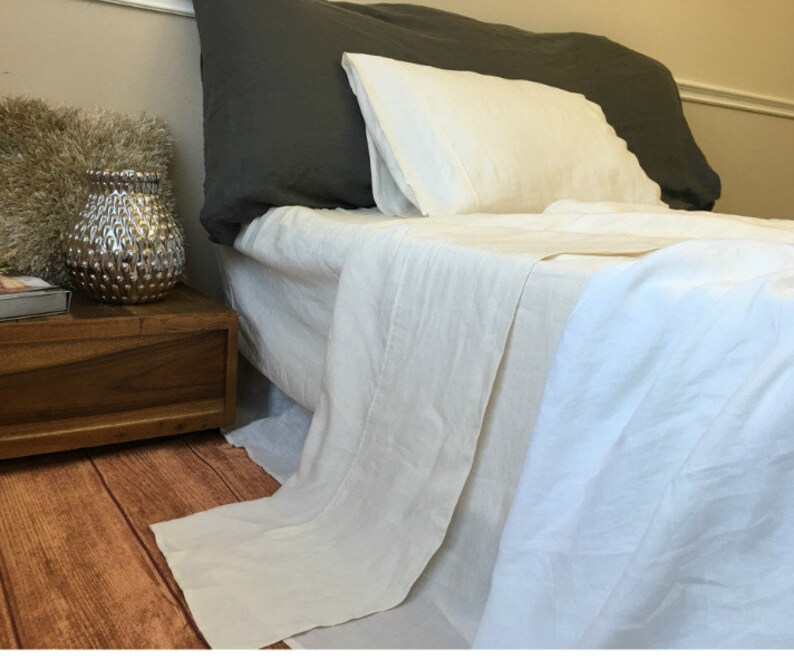May include: A white linen bed sheet set with a fitted sheet, flat sheet, and pillowcases. The sheets are wrinkle-free and have a soft, natural feel.
