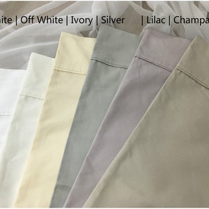 Pu&ograve; includere: Primo piano di sei campioni di tessuto in diversi colori, da sinistra a destra: bianco, avorio, avorio, argento, lilla e champagne. I campioni sono disposti in fila, con il campione bianco in alto e il campione champagne in basso. Il testo "White | Off White | Ivory | Silver | Lilac | Champagne" &egrave; stampato sopra i campioni.