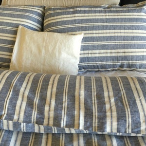 Pu&ograve; includere: Un set di biancheria da letto a righe con un motivo blu e bianco. Il set comprende un copripiumino, due federe e un cuscino.